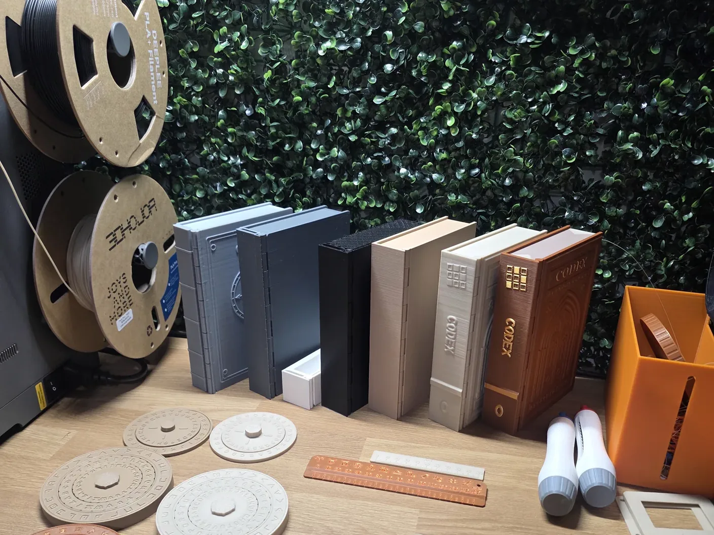 Printed book prototypes, cipher wheels and rulers gathered on Jon’s workbench.